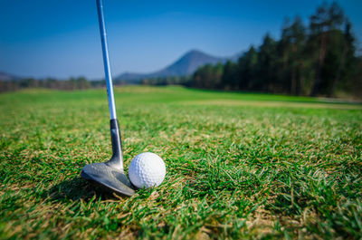 Golf ball with club on grass