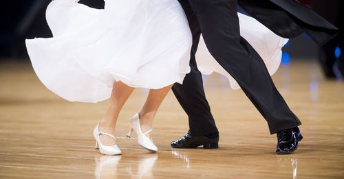 Low section of people dancing on hardwood floor