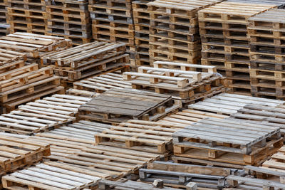 Full frame background of used wooden pallet stacks - perspective view from above