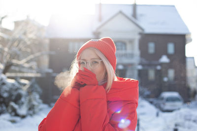 Young stylish blonde woman on the street has fun, posing in snowy, frosty