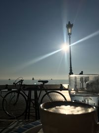 Illuminated street light against sky on sunny day