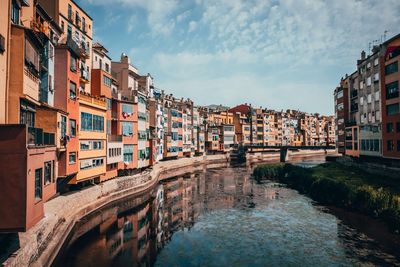 Canal amidst buildings in town against sky