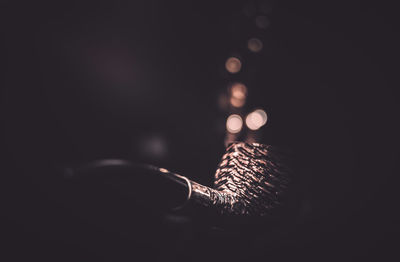 Close-up of illuminated lighting equipment against black background