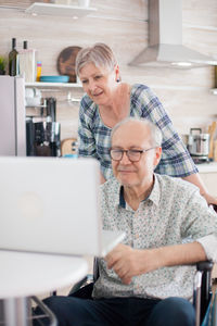 Senior couple using laptop on table at home