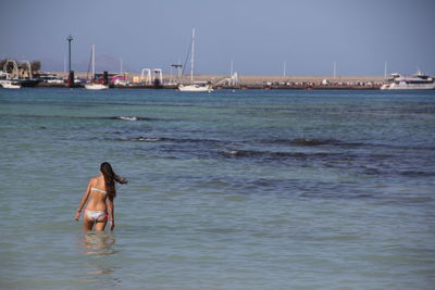 Woman in boat on sea against sky