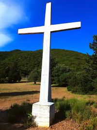 Cross on field against sky