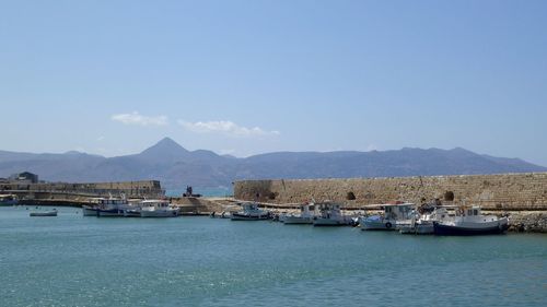 Sailboats moored on sea against sky