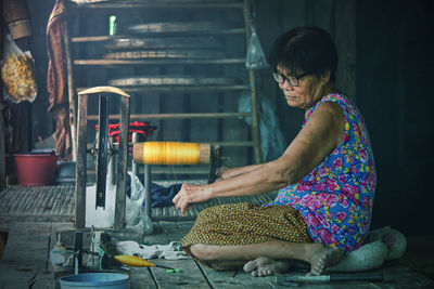 Side view of woman working in workshop