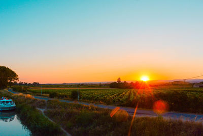 Scenic view of field against clear sky during sunset