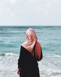 Mid adult woman on beach against sky