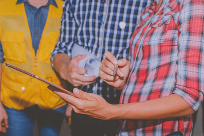 Midsection of man holding mobile phone