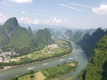 Scenic view of river amidst mountains against sky