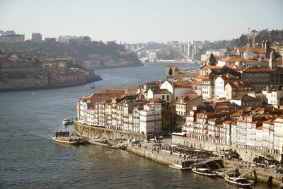 Aerial view of river amidst buildings in city against clear sky