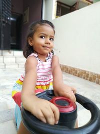 Portrait of smiling girl playing with toy car