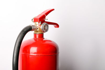Close-up of fire extinguisher against white background