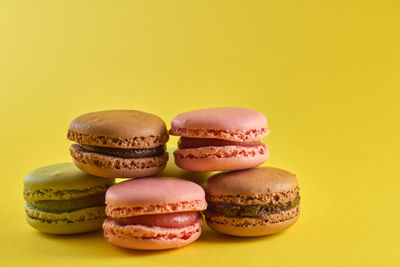 Close-up of multi colored candies against yellow background