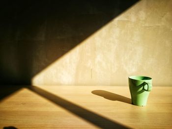 Coffee cup on table against wall