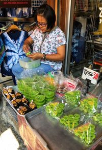 Midsection of woman standing at market stall