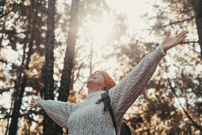 Low angle view of woman standing in forest