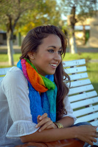 Portrait of a smiling young woman sitting on bench