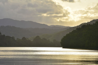 Scenic view of river and mountains against sky