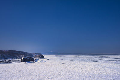 Scenic view of snowcapped mountains against clear blue sky