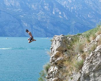 Rear view of man jumping on mountain