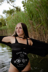 Portrait of young woman standing in water