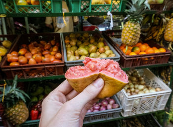 Midsection of person holding fruits at market