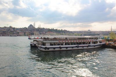 View of boats in river against cloudy sky