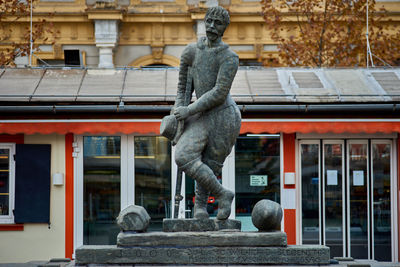 Statue against building in city