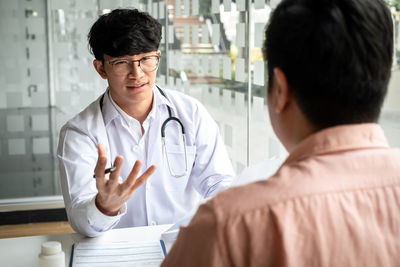 Side view of doctor examining patient in laboratory