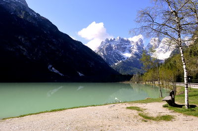 Scenic view of lake by mountains against sky