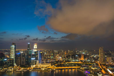 Illuminated buildings in city against sky at night