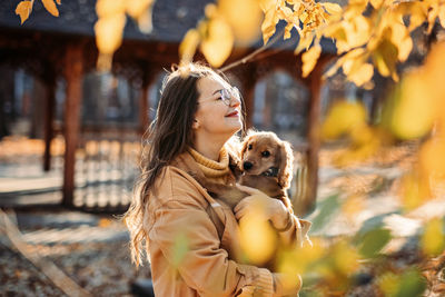 Pet love. cute english cocker spaniel puppy in the hands of the owner in autumn park.