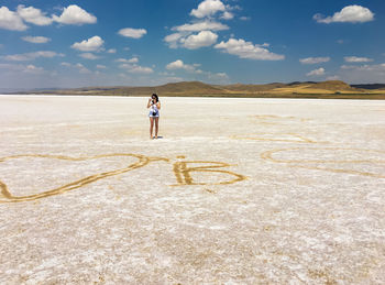 Full length of woman standing on land against sky