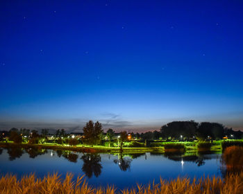 Scenic view of lake against blue sky at night