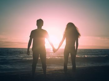 Couple holding hands on beach