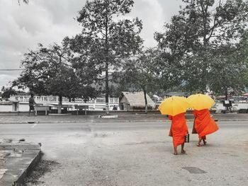 Rear view of people walking on road