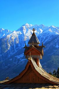 Traditional windmill on mountain against blue sky