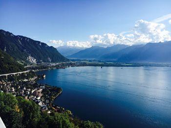 Scenic view of sea and mountains against blue sky