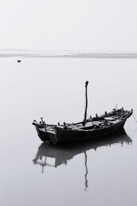 Boat sailing in sea against clear sky