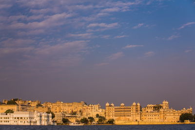 Buildings in city against cloudy sky