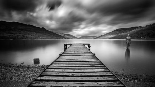 Pier over lake against sky