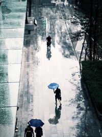 High angle view of people walking on street in rain