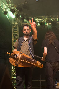 Man playing guitar at illuminated music concert