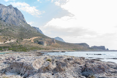 Scenic view of sea and mountains against sky