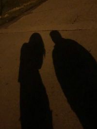 Shadow of man and woman standing on street at night