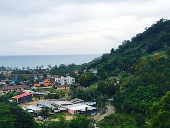 High angle view of townscape by sea against sky