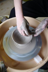Cropped hand of woman making pottery at workshop